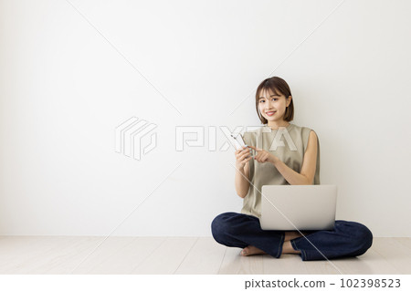 Young woman using laptop and smartphone Young woman using laptop and smartphone 102398523