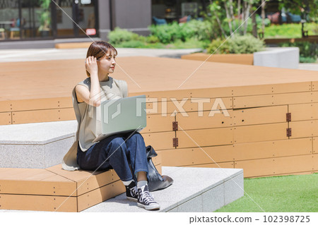 Female college student using a laptop outdoors Female college student using a laptop outdoors 102398725