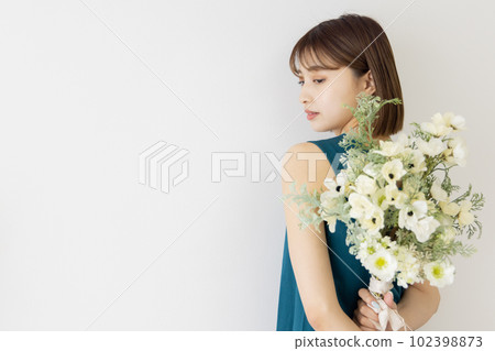 Young woman holding a bouquet of flowers on her back Young woman holding a bouquet of flowers on her back 102398873