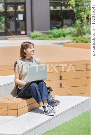 Female college student using a laptop outdoors 102399143