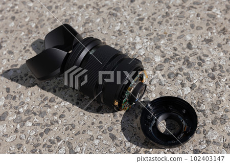 A standard zoom lens that was dropped on the road and broke 102403147