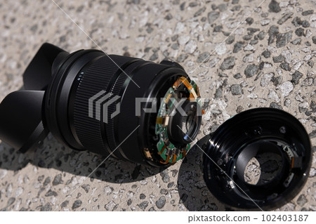 A standard zoom lens that was dropped on the road and broke 102403187