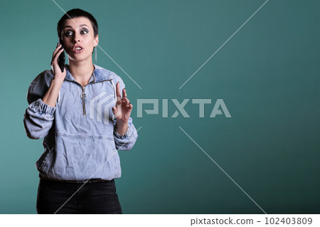 Attractive cheerful woman smiling while having mobile phone conversation with remote friend in studio. Happy female enjoying smarphone discussion standing over isolated background Attractive cheerful woman smiling while having mobile phone conversation with remote friend in studio. Happy female enjoying smarphone discussion standing over isolated background 102403809