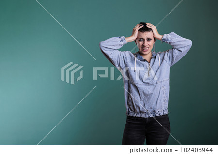 Upset nervous woman putting hand on head trying not to scream after hearing the news during studio shot, posing over isolated background. Sad caucasian female having displeased expression 102403944