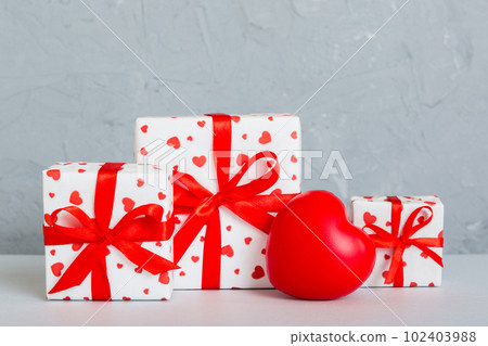gift box with red bow and red heart on colored background. Perspective view. Flat lay gift box with red bow and red heart on colored background. Perspective view. Flat lay 102403988