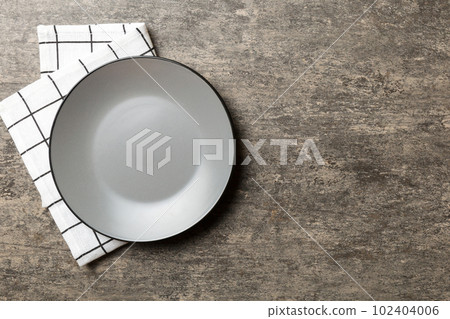 Top view on colored background empty round gray plate on tablecloth for food. Empty dish on napkin with space for your design Top view on colored background empty round gray plate on tablecloth for food. Empty dish on napkin with space for your design 102404006