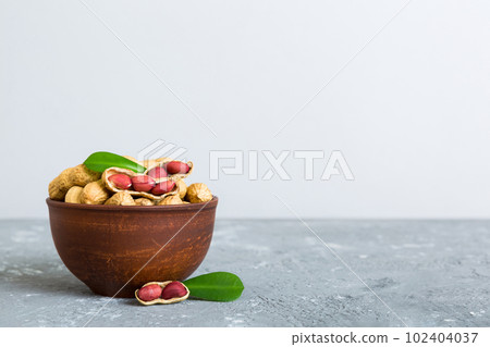 Fresh healthy peanuts in bowl on colored table background. Top view Healthy eating bertholletia concept. Super foods Fresh healthy peanuts in bowl on colored table background. Top view Healthy eating bertholletia concept. Super foods 102404037