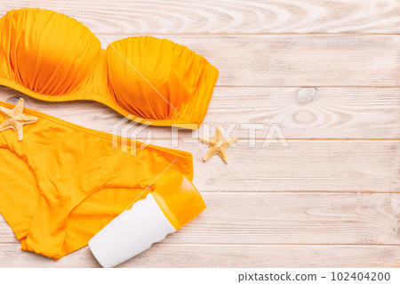 Woman swimwear and beach accessories flat lay top view on colored background Summer travel concept. bikini swimsuit, straw hat and seasheels. Copy space Top view Woman swimwear and beach accessories flat lay top view on colored background Summer travel concept. bikini swimsuit, straw hat and seasheels. Copy space Top view 102404200