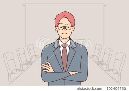 Confident business man stands in boardroom and looks at camera with arms crossed 102404360