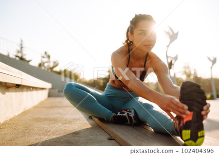 Fit Young woman in sportswear doing yoga, fitness exercise on the street. Sport, Active life. 102404396