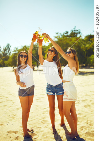 Group of friends hanging out with beer at the beach. Excellent sunny weather. Beautiful figures. 102405597