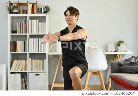 Male athlete in sportswear stretching arms muscular before workout. Healthy lifestyle and fitness concept 102406204