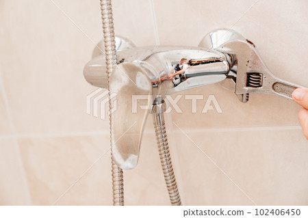 A plumber repairs or installs a faucet faucet in the bathroom A plumber repairs or installs a faucet faucet in the bathroom 102406450