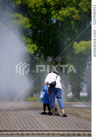 Child approaching fountain and mother holding back Child approaching fountain and mother holding back 102406451