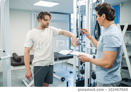 Male patient have a physical therapy session in rehabilitation center 102407668