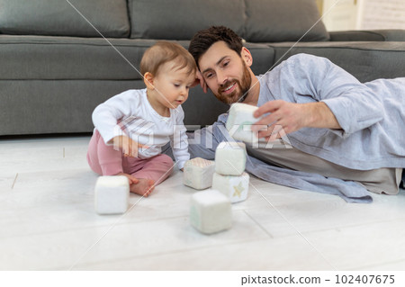 Caring young single father playing with cute kid daughter with soft blocks building tower. Caring young single father playing with cute kid daughter with soft blocks building tower. 102407675