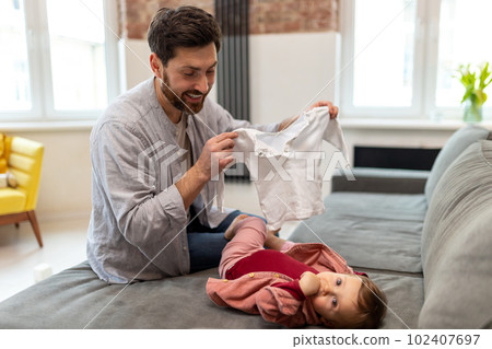 Father with toddler daughter, taking care of his baby changing clothes. 102407697