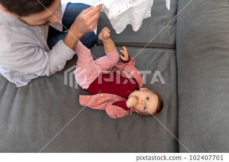 Father with toddler daughter, taking care of his baby changing clothes. 102407701