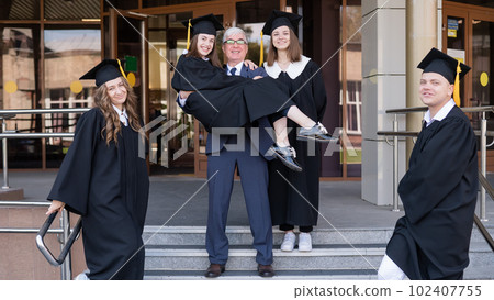 The teacher holds the graduate in his arms. The teacher holds the graduate in his arms. 102407755