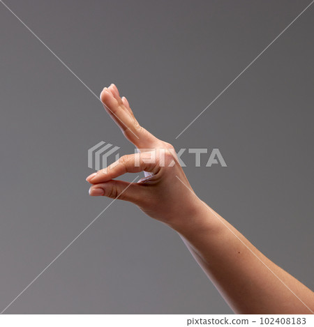 Female hand showing gesture against grey background. Playing with gestures, making figures with fingers Female hand showing gesture against grey background. Playing with gestures, making figures with fingers 102408183