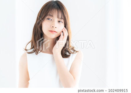 Young woman doing skin care by the window in the living room Young woman doing skin care by the window in the living room 102409915