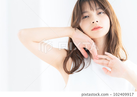 Young woman doing skin care by the window in the living room Young woman doing skin care by the window in the living room 102409917