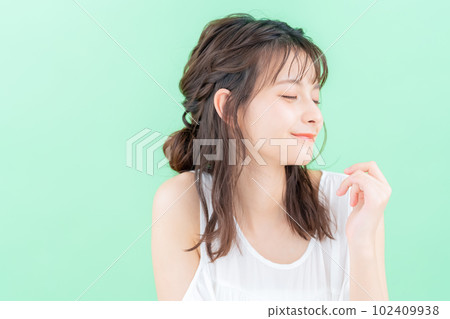 Young woman doing skin care on green background 102409938