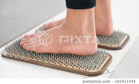 Close-up of female feet on sadhu boards.  102411545