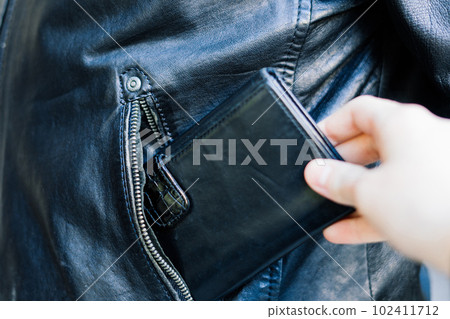 From the pocket of jacket the thief pulls out a card banknote money purse wallet. From the pocket of jacket the thief pulls out a card banknote money purse wallet. 102411712