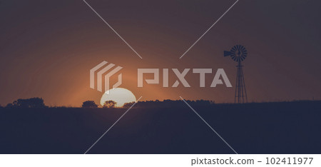 Windmill in countryside at sunset, Pampas,  102411977
