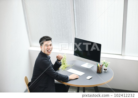 在辦公室用電腦工作的年輕人 在辦公室用電腦工作的年輕人 102412232