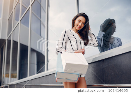 Beautiful girl in a summer city. Lady with shopping bags 102414695