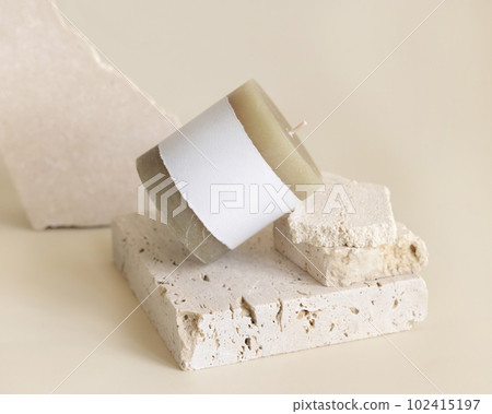 Candle with label on beige near cream travertine stones, Close up. Packaging mock up Candle with label on beige near cream travertine stones, Close up. Packaging mock up 102415197
