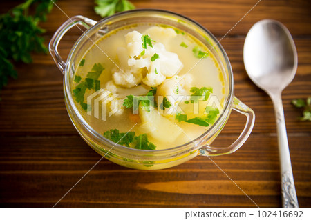 cooked chicken soup with cauliflower and vegetables in a bowl 102416692