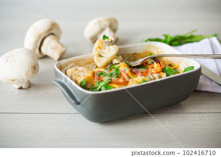 cauliflower baked with chicken fillet and mushrooms under cheese in a ceramic form cauliflower baked with chicken fillet and mushrooms under cheese in a ceramic form 102416710
