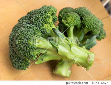 healthy broccoli and florets on wooden board healthy broccoli and florets on wooden board 102416876