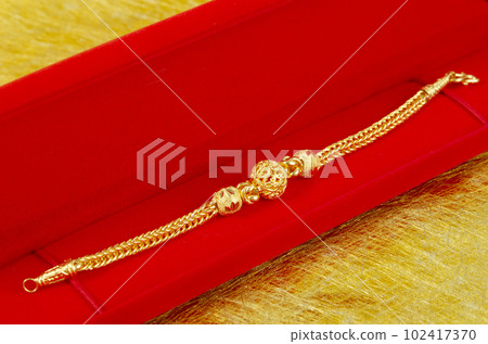 The Gold Bracelet in red velvet box container. 102417370