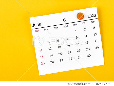 The June 2023 and wooden push pin on yellow background. 102417380