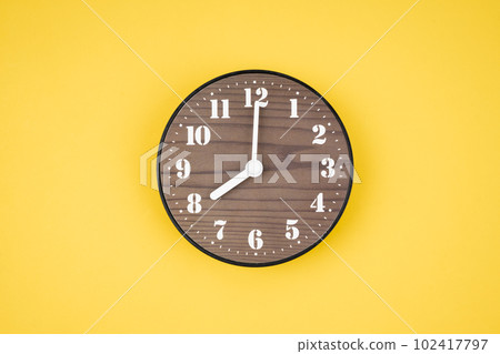 The Retro wooden clock at 8 O' clock on yellow color background. The Retro wooden clock at 8 O' clock on yellow color background. 102417797