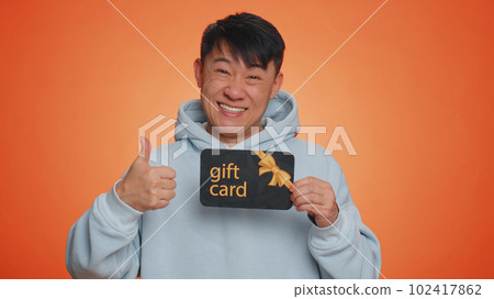 Handsome man showing pointing on gift discount certificate voucher coupon for store holidays sale Handsome man showing pointing on gift discount certificate voucher coupon for store holidays sale 102417862
