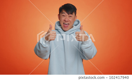 Asian business man showing thumbs up and nodding in approval, successful good work, nice great job 102417940
