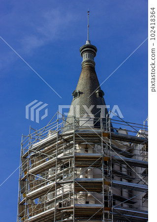 A dome of the historic building reconstruction. Restoration of an old house facade. Scaffolding moldings on construction site. Reestablishment, refurbishment, reinstallation, reinstatement, renovation 102418364