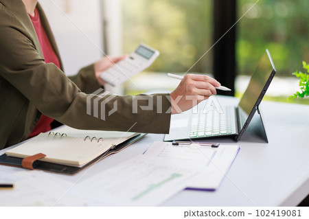 Concept of business office woman working,Closeup businesswoman checking her invesment plan with analyzing document and business investment graph data by using calculator and laptop Concept of business office woman working,Closeup businesswoman checking her invesment plan with analyzing document and business investment graph data by using calculator and laptop 102419081