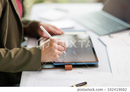 Concept of business office woman working,Closeup businesswoman checking her invesment plan with analyzing document and business investment graph data by using calculator and laptop Concept of business office woman working,Closeup businesswoman checking her invesment plan with analyzing document and business investment graph data by using calculator and laptop 102419082