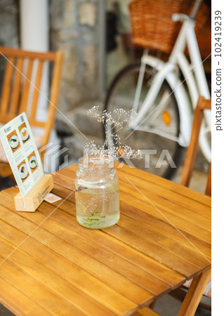 a vase of flowers on a table in a cafe outside a vase of flowers on a table in a cafe outside 102419239
