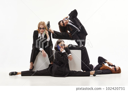 Portrait with group of beautiful women, ballet dancer in classical suit posing over white color studio background. Office ballerinas 102420731