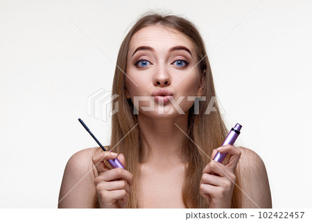 young woman hold mascara isolated on white background 102422457