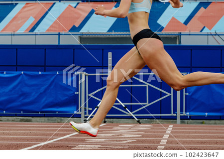 close-up female athlete finishing sprint race at stadium in summer athletics championships close-up female athlete finishing sprint race at stadium in summer athletics championships 102423647