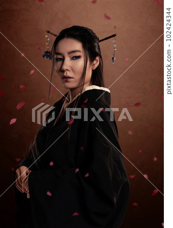 Japanese woman samurai wearing kimono on brown background and flower petals. Japanese culture 102424344