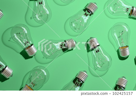 Close-up of an incandescent lamp on green background. Close-up of an incandescent lamp on green background. 102425157